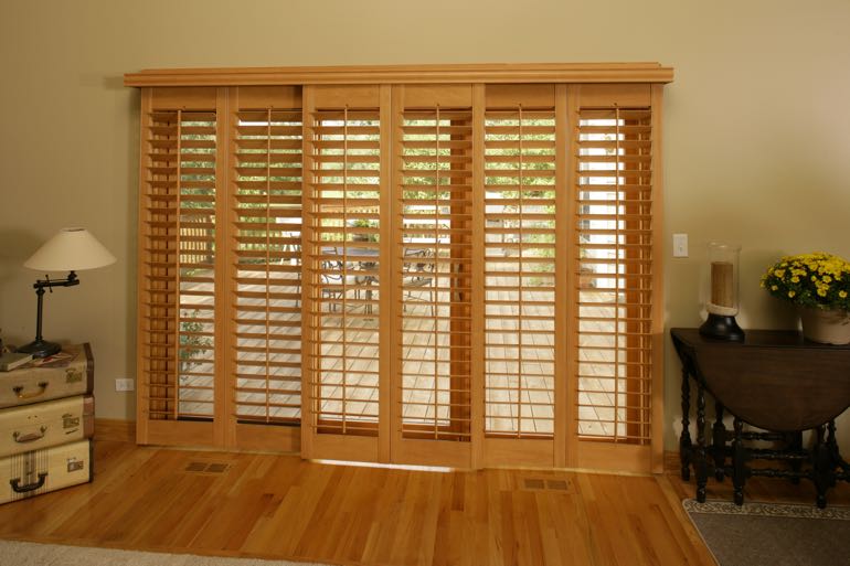 plantation shutters on sliding door going to outdoor porch.